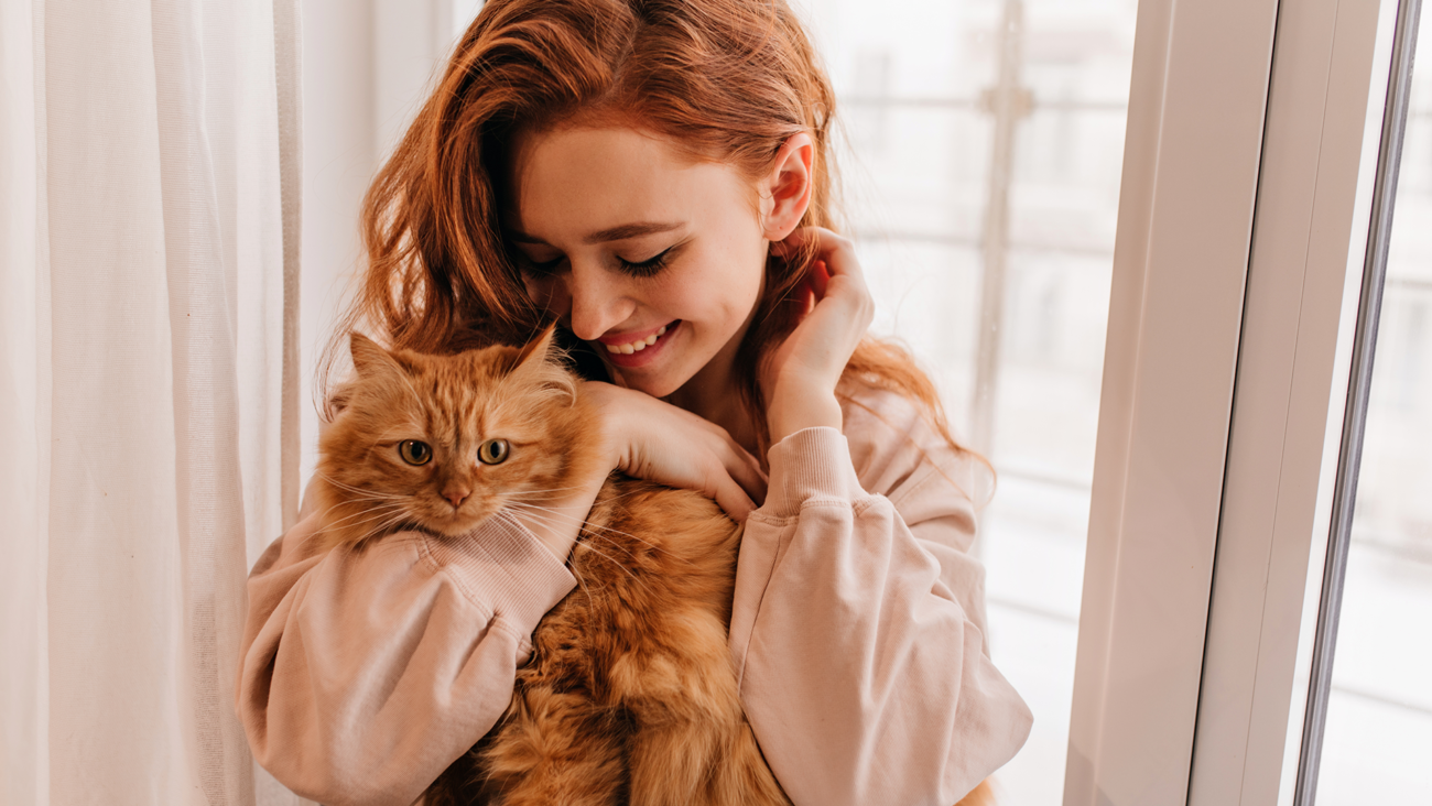 Właścicielka przytulająca rudego kota