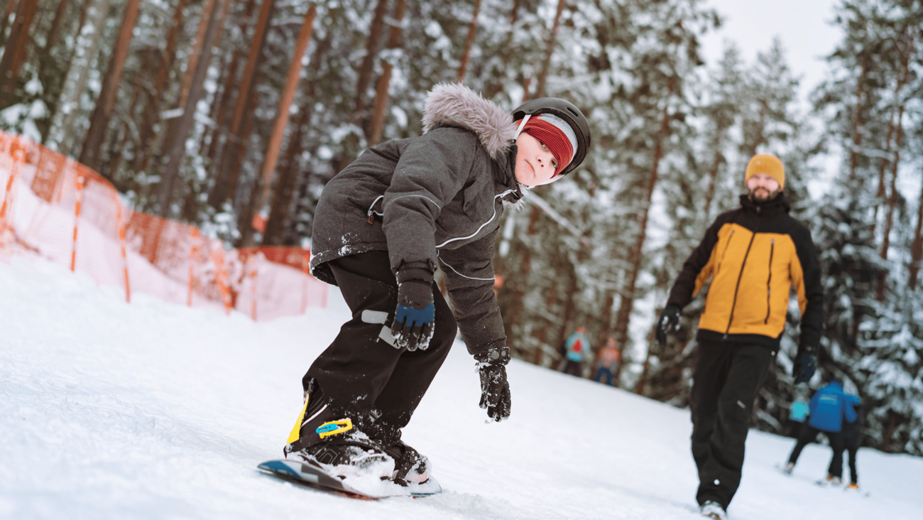 Kilkuletni chłopiec jeżdżący na desce snowboardowej